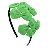 A green grosgrain headband adorned with multiple bows with black stitching 